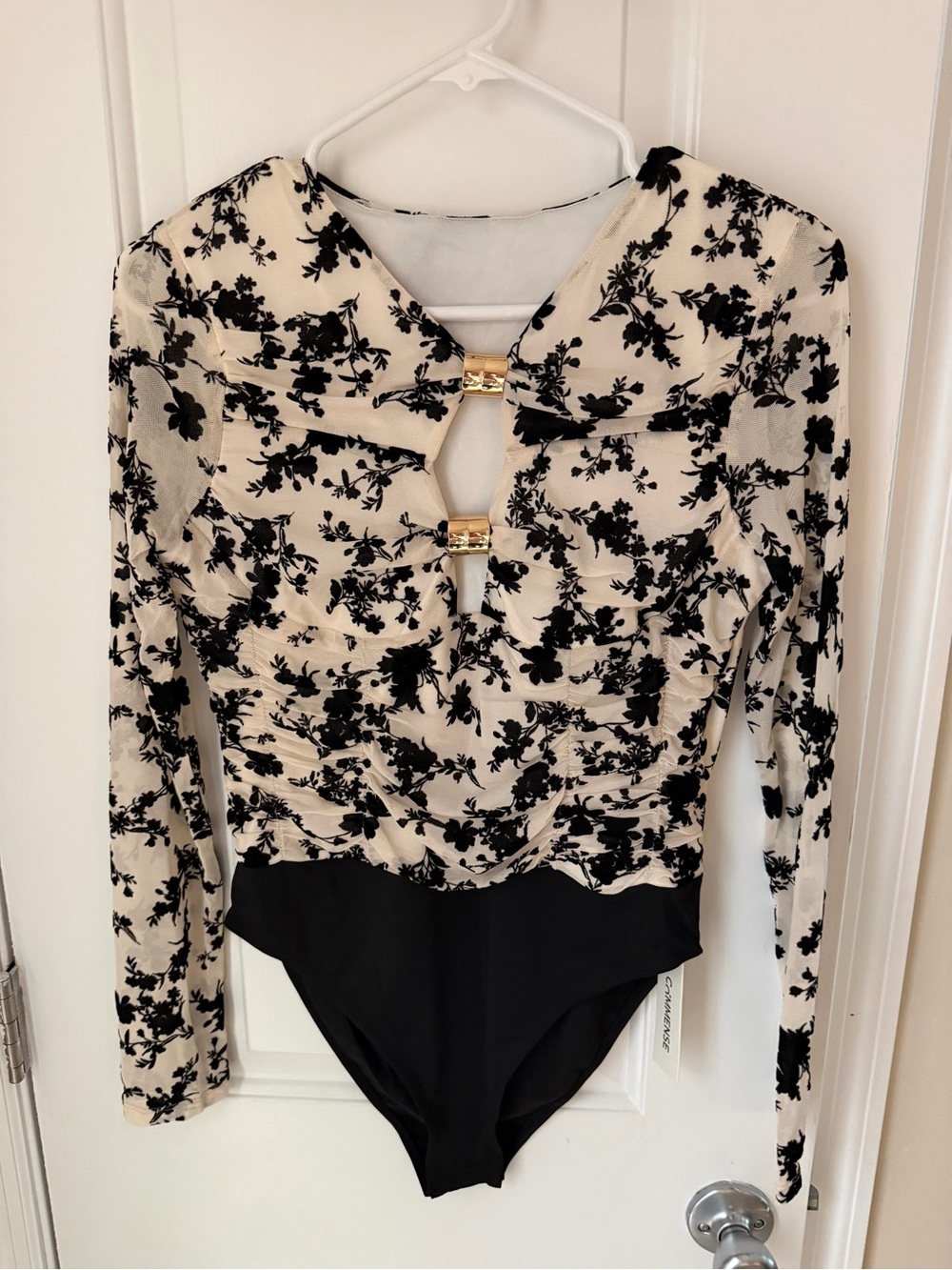 Commense Black Floral Long-Sleeve Bodysuit on Cream with Gold Hardware
